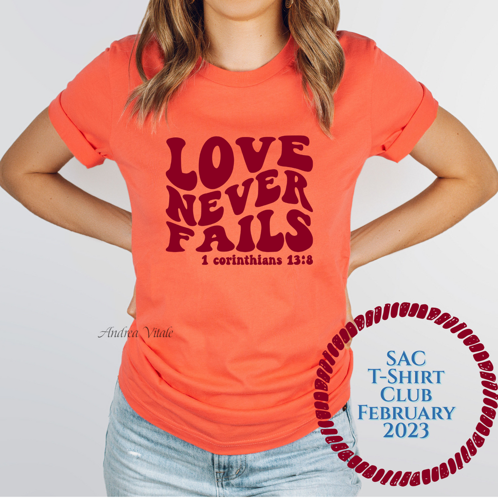 Love Never Fails with Burgundy Text - Bella Canvas 3001 Coral - SAC T-Shirt Club February 2023 - Sky Angel Cafe
